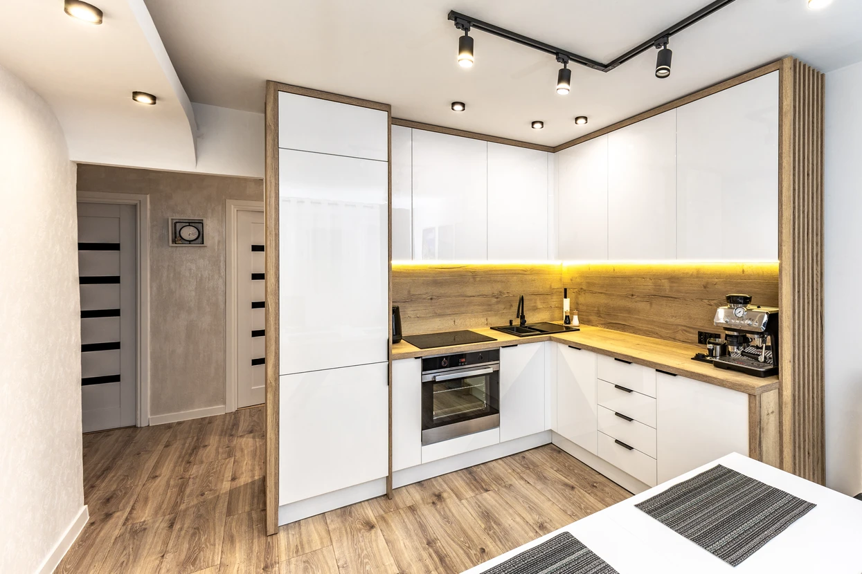 Salon moderne avec cheminée d'angle et rangement bois intégré, mur TV en panneaux béton gris, escalier contemporain