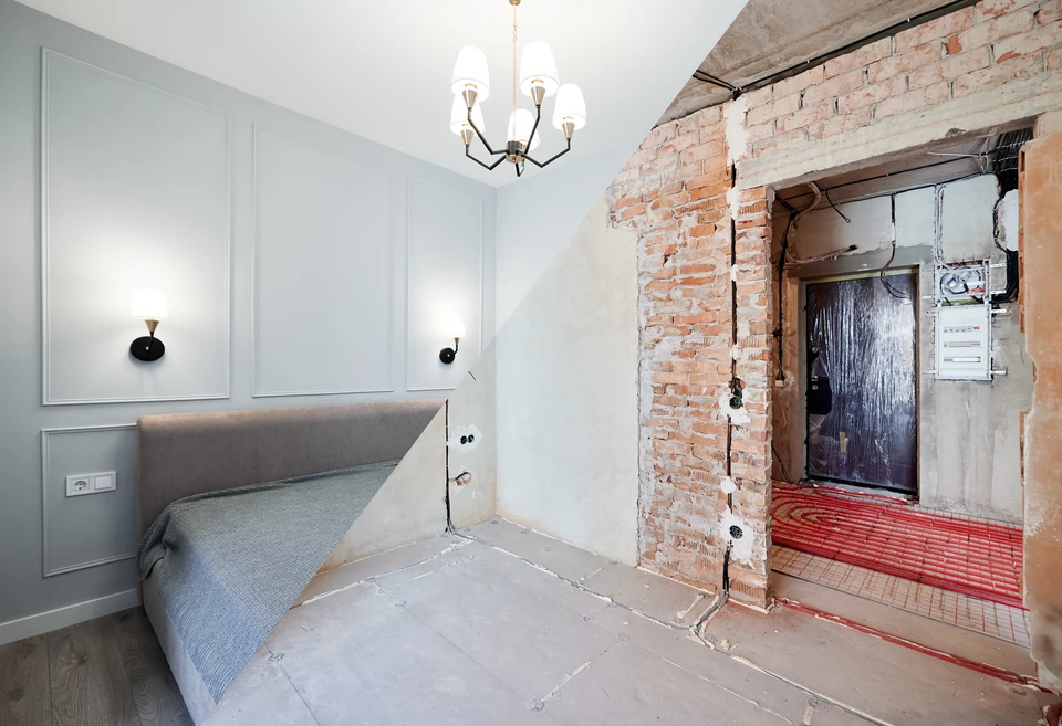 Un homme en chemise verte travaille dans un atelier de menuiserie, parlant au téléphone tout en consultant des documents sur un établi en bois