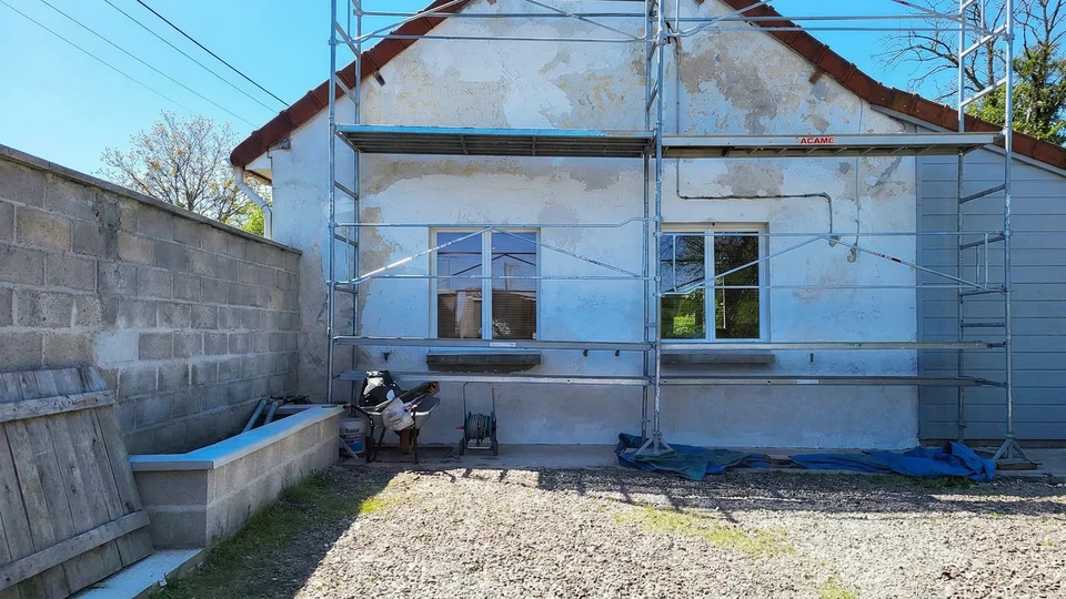 Livreur souriant en uniforme bleu et casquette jaune tenant un colis, debout près d'un chronomètre géant et de cartons empilés sur fond turquoise dégradé